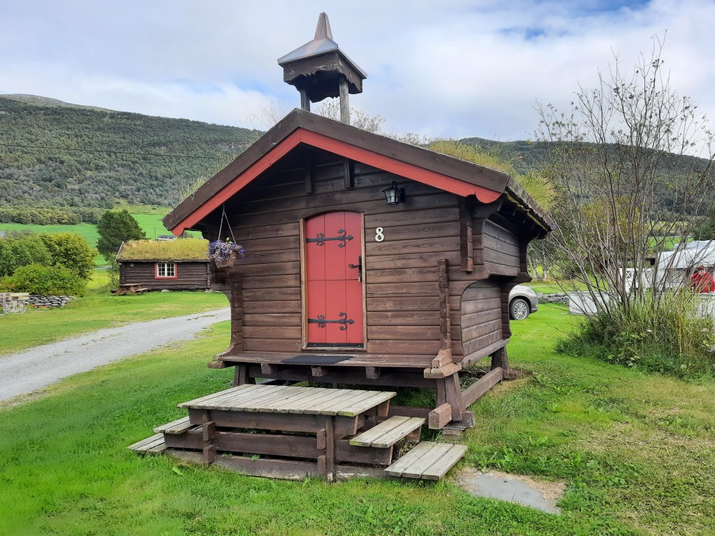 Eine kleine Holzhütte dient als Unterkunft für Pilger auf einem Campingplatz.