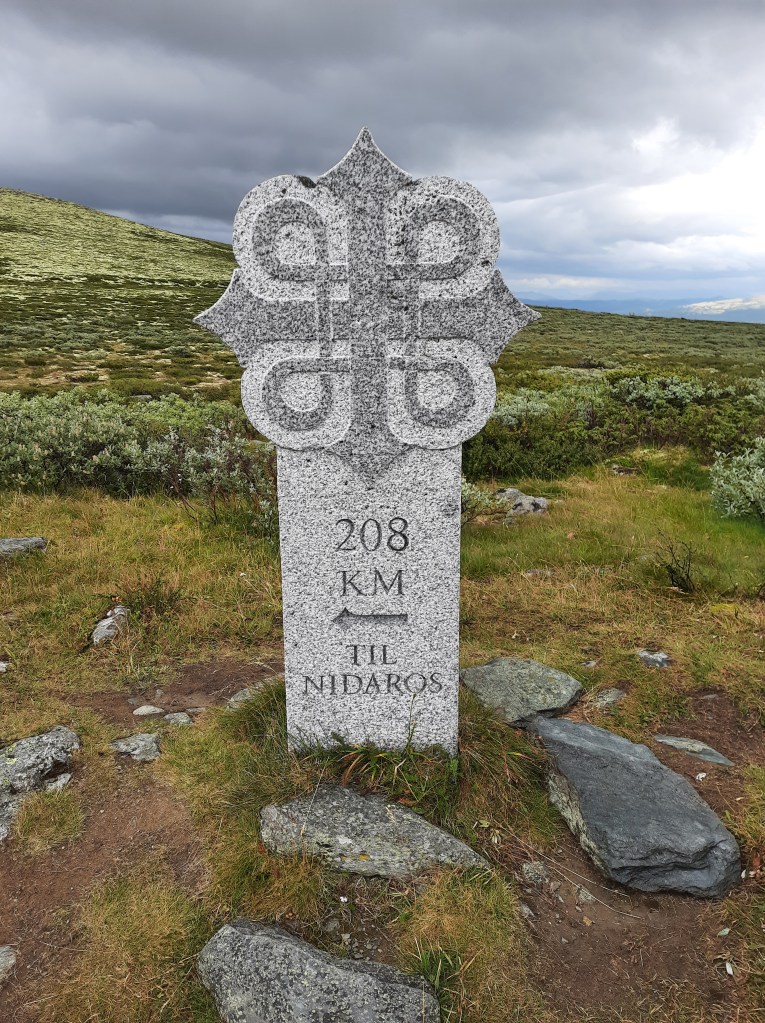 Ein Meilenstein mit dem Olavsweg zeigt wie viel Distanz noch vor einem liegt.